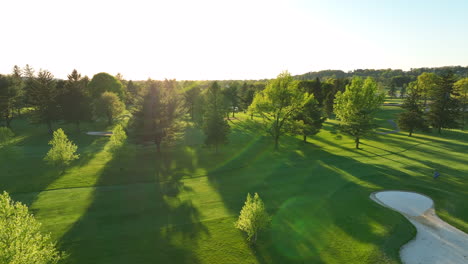Aerial-shot-of-golfer-walking-through-beautiful-green