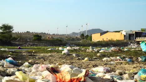 Urban-scene-with-scattered-garbage,-wind-turbines-in-background,-Vietnam