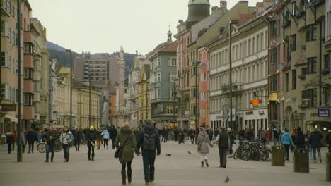 Pedestrians-enjoy-Innsbruck-busy-city-square-with-colorful-buildings