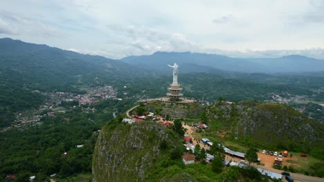 Antena-De-Una-Estatua-De-Jesucristo-En-Tana-Toraja-Sulawesi-En-La-Cima-De-Una-Montaña-Con-Turistas-Y-Tiendas