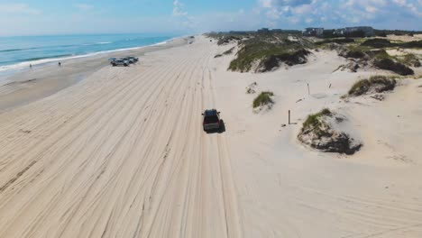 Drone-following-black-suv-on-Outer-Banks-Corolla-4x4-beach