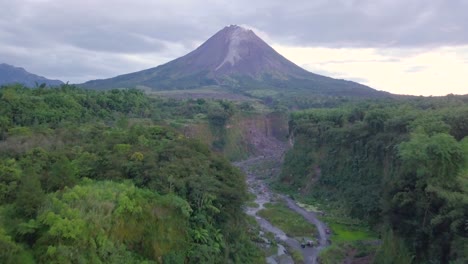 Vista-Aérea-De-Mostrar-La-Pendiente-Del-Volcán-Merapi-En-Indonesia-Y-El-Camino-De-Lava-Seca-Durante-Las-Nubes-En-El-Cielo---Bego-Pendem,-Indonesia
