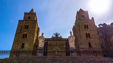 Low-angle-shot-of-Cefalù-Cathedral-in-Sicily,-southern-Italy-on-a-sunny-day-with-tourists-movement-in-timelapse