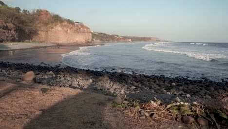 Stone-filled-coastline-hit-by-waves-at-Punta-Mango,-El-Salvador,-Handheld-wide-shot