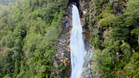 Aerial-orbit-of-the-Rio-Blanco-waterfall-surrounded-by-the-forest-of-Hornopiren-National-Park,-Chile