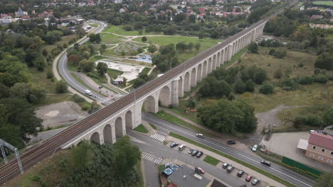 Luftaufnahme-Des-Eisenbahnviadukts-über-Den-Bobr-Fluss-Und-Des-Skateparks-In-Bunzlau,-Niederschlesien,-Polen