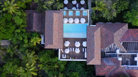 Aerial-top-down-shot-of-old-villa-with-pool-and-beautiful-palm-tree-garden-on-Dominican-Republic