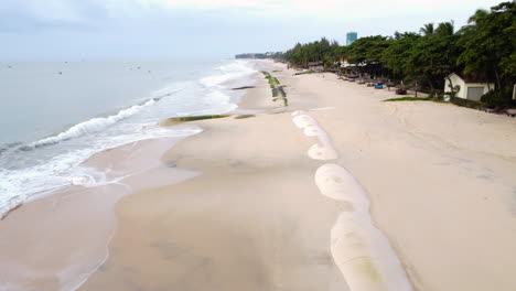 Aerial,-beach-in-Vietnam-with-barriers-to-prevent-climate-change-sea-level-rise