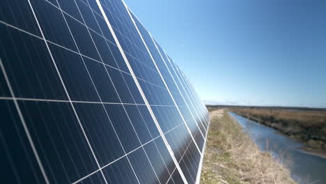 closeup-of-solar-panels-in-a-field-by-the-rivere