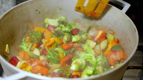 Wooden-Spatula-Stirring-Vegetable-Pot-With-Broccoli,-Beetroot,-Carrots-With-Steam-Rising-From-It