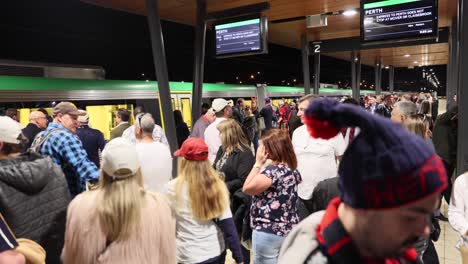 Belebter-U-Bahn-Zug,-Der-Nachts-Am-Bahnsteig-Ankommt,-Passagiere,-Die-Perth,-Australien,-Verlassen