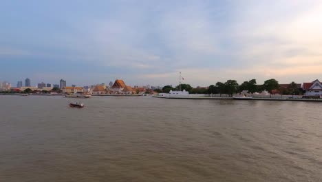 Vista-Del-Templo-Budista-Wat-Kalayanamit-Woramahawihan-Junto-Al-Río-Chao-Phraya-En-La-Noche-Al-Atardecer,-Bangkok,-Tailandia
