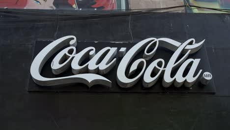 Coca-Cola-Sign-Against-Black-Background-At-Refreshing-Center-In-Mexico-City