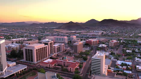 Tucson-Arizona,-aerial-drone-descending-over-Old-Pima-County-Courthouse-during-vibrant-sunset