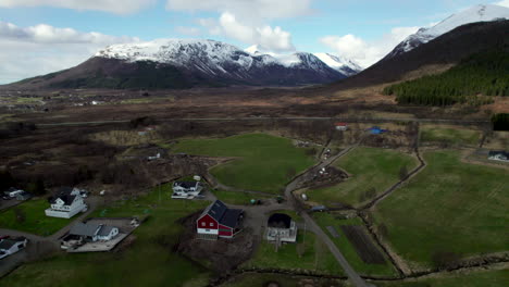 Aufsteigende-Luftaufnahme-über-Einem-Norwegischen-Dorf-Mit-Malerischen-Bergen-Tagsüber-Im-Norden-Skandinaviens