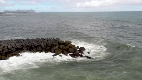 Close-up-of-breaker-rocks-in-Atlantic-Ocean-in-Vik,-Iceland-with-stable-drone-video