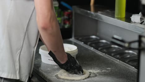 kneading-the-dough-in-pizza-gloves
