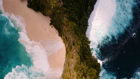 Overhead-view-of-cliffs-and-waves-breaking-on-Kelingking-beach,-Nusa-Penida