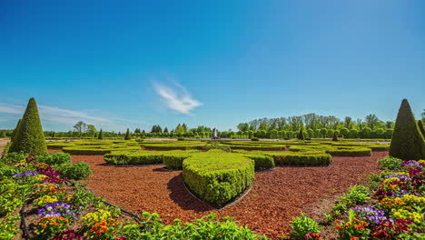 Static-shot-of-a-beautiful-masterpiece-of-topiary-art-surrounded-by-colorful-floral-plants-in-timelapse-on-a-bright-sunny-day