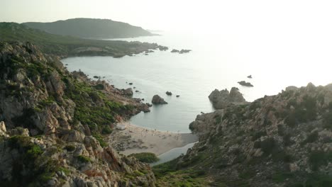 revealing-aerial-shot-of-exotic-small-beach-between-mountains-on-Italian-Sardinia-island