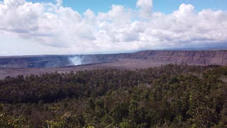 Toma-Panorámica-Súper-Amplia-De-Mano-Del-Volcán-Kilauea-Con-Humo-Saliendo-Del-Caldero-En-La-Isla-Grande-De-Hawaii