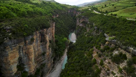 Filmische-Luftdrohnenaufnahme-Der-Schluchten-Des-Osumi-Flusses-In-Skrapar,-Albanien-Mit-Felsformationen-Und-Einer-Natürlichen-Landschaft-Mit-Einem-Fluss,-Der-Zwischen-Den-Beiden-Schluchten-Fließt