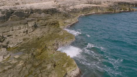 Luftaufnahmen-In-Zeitlupe-Von-Wellen,-Die-Auf-Die-Felsen-Und-Das-Ufer-In-Polignano-A-Mare,-Italien,-Treffen
