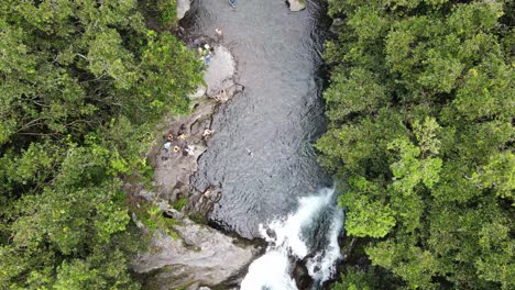 Top-down-drone-footage-of-a-river-with-people-swimming-at-the-Reunion-island