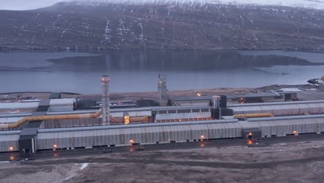 Industrial-aluminium-factory-on-fjord-shore-in-Iceland,-aerial