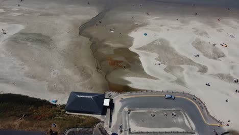 Drone-shot-of-a-truck-driving-to-park-at-Nye-Beach-in-Newport,-Oregon