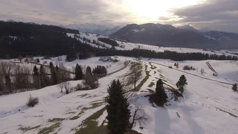 Hermoso-Panorama-Invernal-En-Suiza,-Con-Un-Automóvil-Conduciendo-Por-Una-Carretera-Con-Curvas