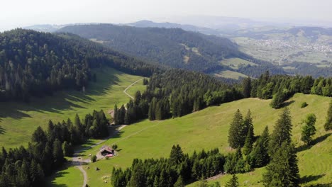 Hut-by-hiking-trail-in-peaceful-alpine-valley-in-Switzerland,-aerial