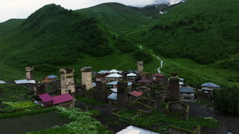 Torres-De-Roca-Y-Casas-Antiguas-En-El-Asentamiento-Ushguli-Con-Un-Exuberante-Valle-En-Svaneti,-Georgia