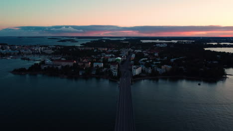 Aerial-view-over-the-Lauttasaarensilta-bridge-towards-Lauttasaari,-dusk-in-Helsinki,-Finland