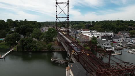 An-aerial-view-over-the-Saugatuck-River-Railroad-Bridge-in-Connecticut-on-a-beautiful-day-with-white-clouds