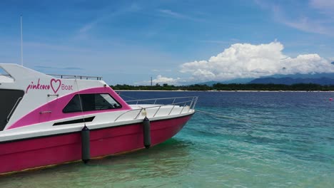 speedboat-anchored-on-tropical-island-beach-in-Indonesia-on-sunny-day,-aerial