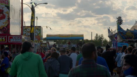 A-crowd-of-Fair-goers-walking-through-the-fair-grounds,-through-a-large-crowd-of-other-people-wandering