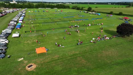 Wide-aerial-shot-of-grass-volleyball-tournament-surrounded-by-farmland-in-Manheim,-PA