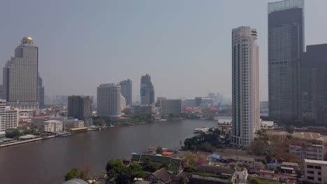 Vista-En-Cámara-Lenta-Del-Río-Chao-Phraya-En-Bangkok-Con-El-Edificio-Bangkok-Higrise-En-La-Orilla-Del-Río