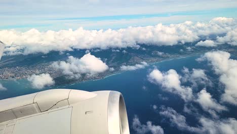 Plane-Flying-by-Island-with-Aircraft-Wing-And-Engine-Seen-From-The-Window-Of-An-Airplane