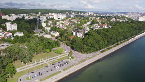 Aerial-wide-shot-showing-parking-area-at-shoreline-of-Baltic-Sea-and-luxury-district-of-Gdynia-in-background