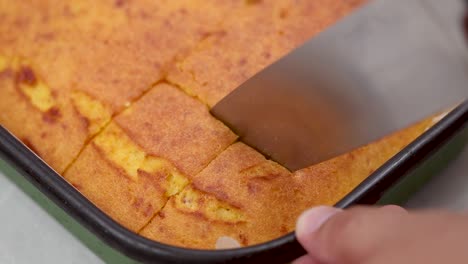 Slicing-corn-pie-in-the-baking-tray-closeup-look