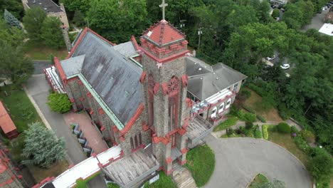 An-aerial-view-of-a-large-church-in-a-suburban-neighborhood-on-Long-Island,-NY-with-green-trees-on-a-cloudy-day