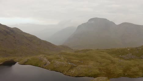 Pullback-Drone-Shot-of-Mountain-and-Lake-in-England-during-Morning-in-Overcast-Weather