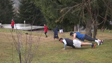 Men-doing-push-ups-in-grass-outside-in-park