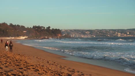 People-Walking-At-The-Reñaca-Beach-During-Golden-Hour-In-Valparaiso,-Chile