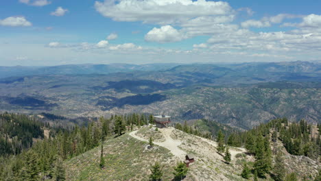 Aerial-passing-fire-lookout-station-on-top-of-mountain-in-national-forest