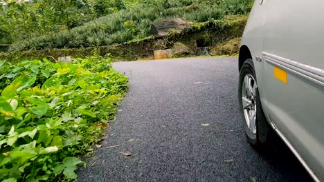 Follow-shot-of-car-running-around-the-hair-pin-bend-in-the-mountains-in-vagamon,-kerala,-India