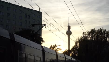 Tram-at-railway-station-in-Berlin-during-lovely-sunset-with-TV-Tower