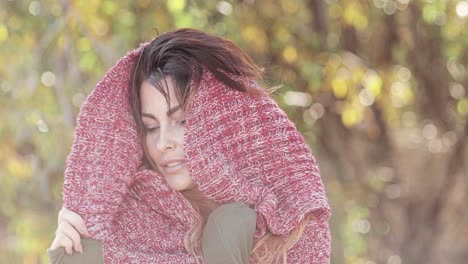 Portrait-of-a-beautiful-brunette-fashion-model-posing-outdoors-wearing-a-knit-scarf